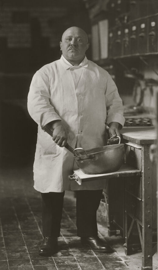 Das Foto von Sander zeigt einen Koch, der in einer Schüssel rührt